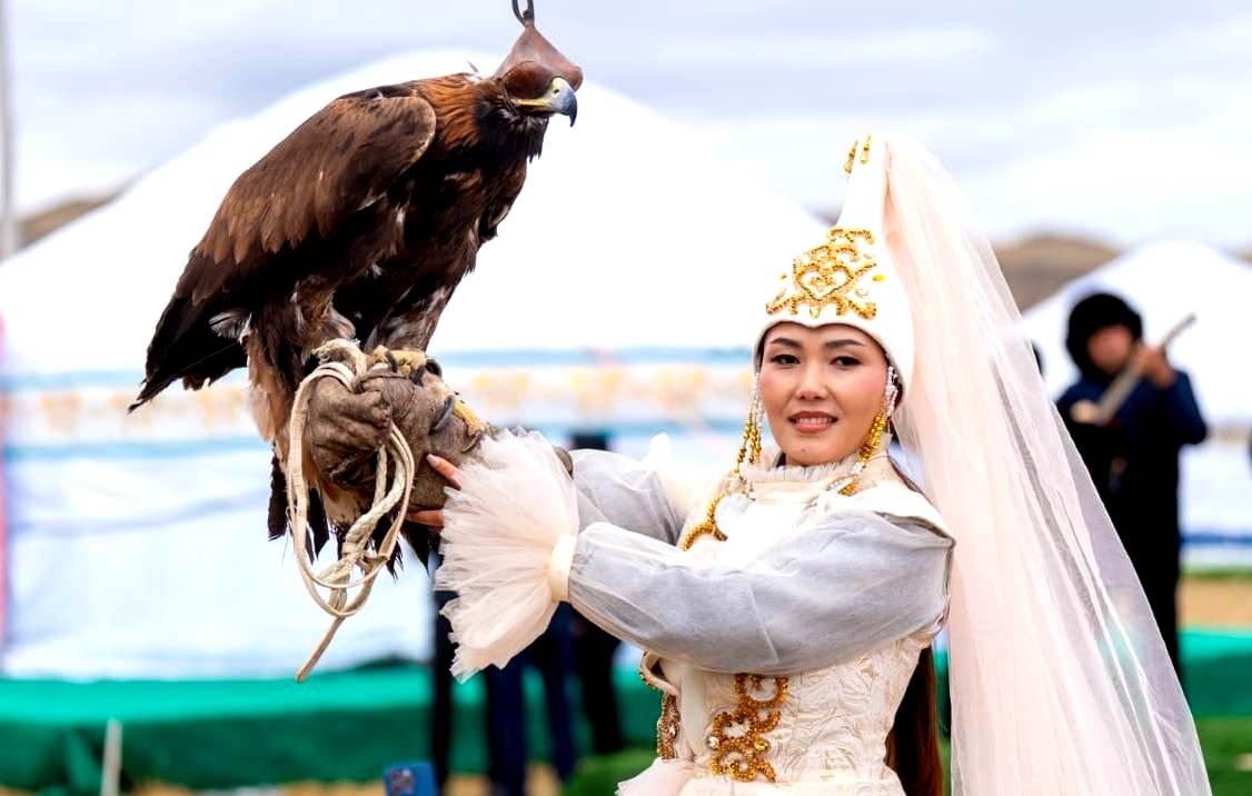 Shygys Salburyny festivalinde altın kartal tutan bir katılımcı